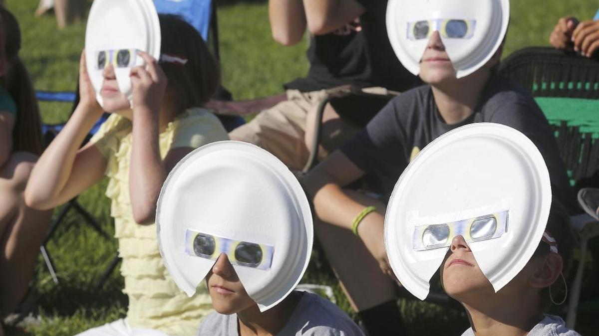 Eclipse glasses fitted to paper plates add an extra measure of safety for viewing Monday's historic event at the Pasco campus of Columbia Basin College. In the back row are: Lora Cahoon, left, 10 and her brother, Cole, 13. Twin brothers Triston, left, and Trenton Humphreys are in front. The youngsters were part of a three-family group from West Richland watching the historic event.