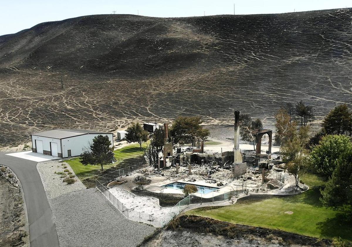 August 13, 2018 - Brick columns are all that remain of this house Sunday at the south end of South Ely Street after a devastating wind-driven fire swept across the hill in south Kennewick from the Bofer Canyon Road area the previous day.
