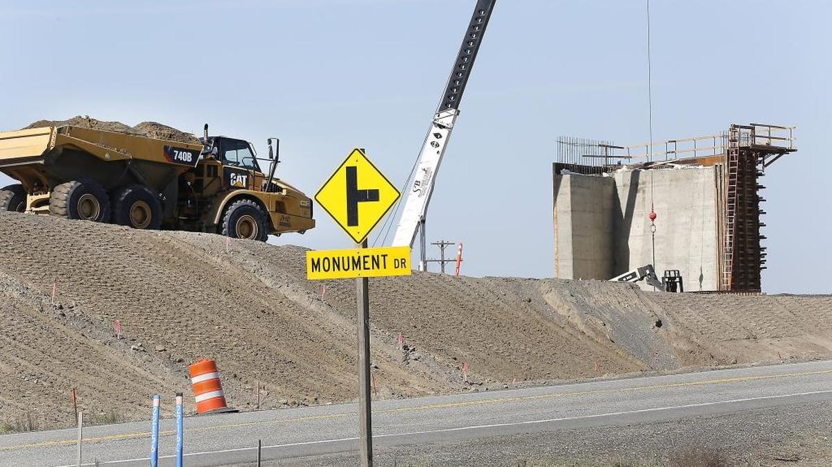 A large dump truck hauls a load of dirt Tuesday for a new $11 million overpass on Highway 124 about five miles from Burbank. Workers from Seattle-based Scarsella Brothers are building the overpass at the Union Pacific railroad crossing that will realign Monument Drive, which currently parallels the tracks. The new bridge eliminates a dangerous railroad crossing. Motorists can expect potential delays until the project is finished in October.