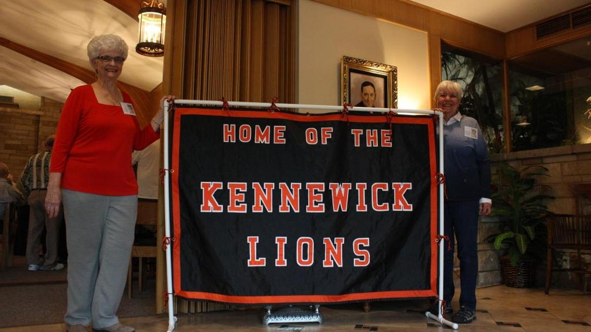 Gail Mueller, left, and Mary Ellen Smithson stand proudly next to the Kennewick High Lions reunion sign at their 60th class reunion Friday. Both were cheerleaders and have known each other since elementary school. Mueller let the alumni hold the first part of their reunion at her family owned funeral home on First Avenue in Kennewick.