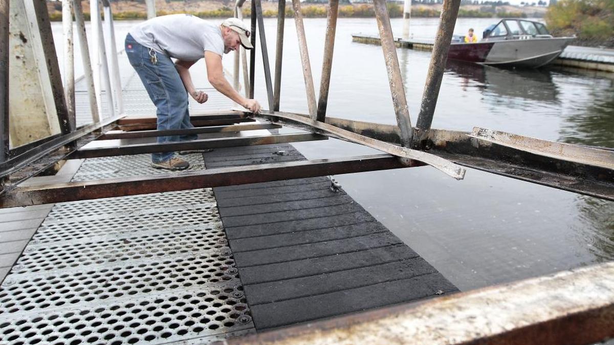 
Richland employee Brian Johnson works Wednesday to repair the walkway and floating dock at the Snyder Street boat launch in Richland. The dock was closed Tuesday after an 18-foot aluminum boat caught fire while tied to it. Workers say the dock is safe and it has reopened. It will be repainted when the busy salmon fishing season ends.
