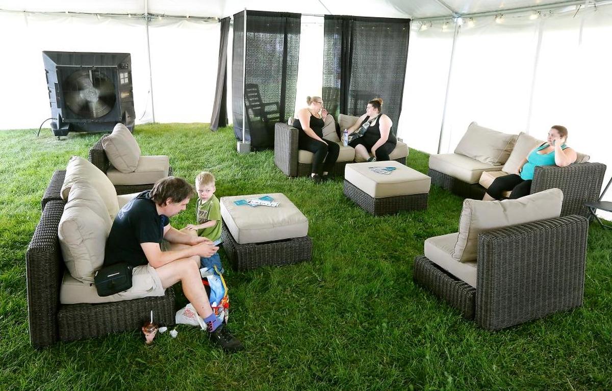 Peter Renberg and his son, Jonah, 3, enjoy the comfortable furniture filling the Lourdes Family Rejuvenation Station near the Kids’ Zone at this year’s Benton Franklin Fair & Rodeo in Kennewick. The tented area has a cellphone charging station and a private area for diaper changing and breastfeeding. Summer Dean, Kylee Pease and Jasmine Pease, from left, also relax in the shaded and cooled area. Watch a video at tricityherald.com/video