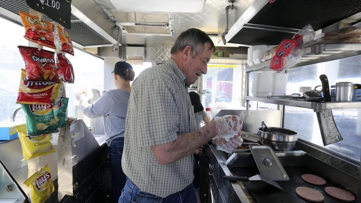 Jim Warren of Pasco puts burgers on the grill as wife Peggy prepares fries and granddaughter Lillian Bates, 12, sets up the ordering system at their food truck — Jiggy’s —during Food Truck Friday at Peanuts Park in downtown Pasco. The weekly event will continue through the summer, featuring six to eight food trucks from 11 a.m. to 2 p.m. every Friday. See a video at tricityherald.com/video.
