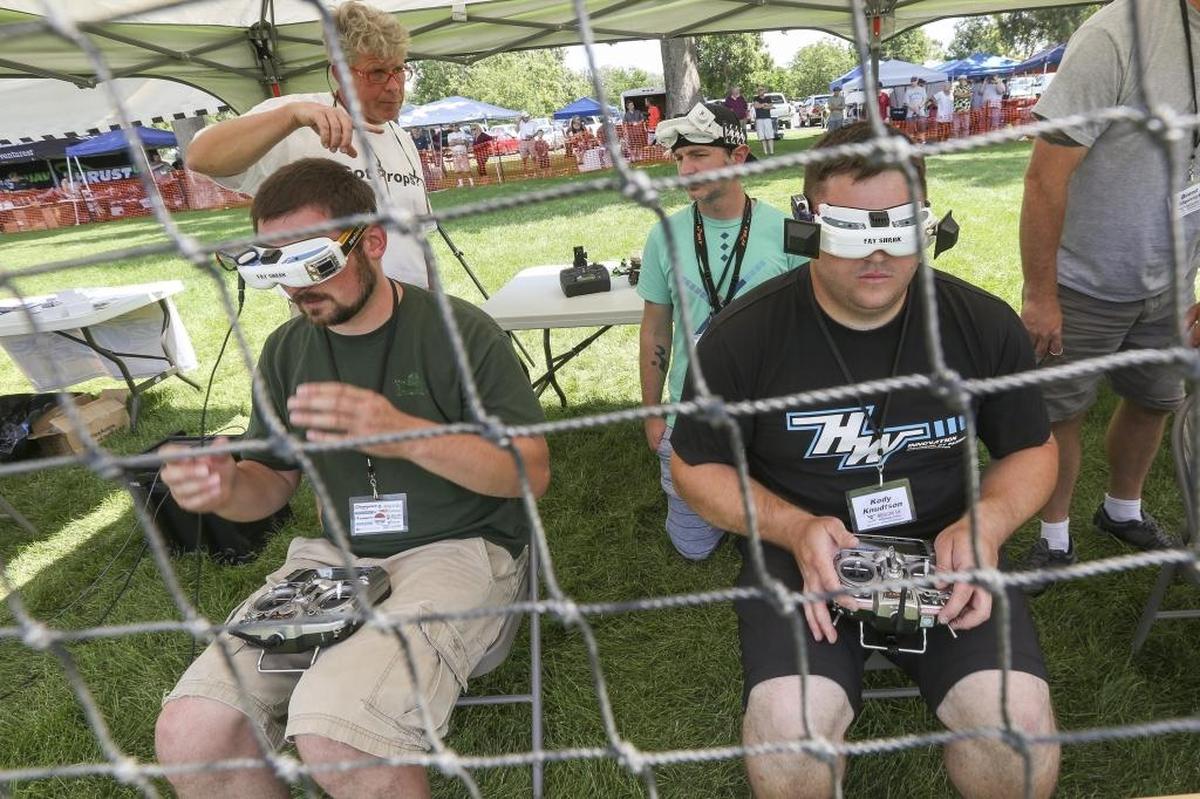 Pilots Howard Green, left, and Kody Knudtson get situated after putting on their goggles during the the MultiGP Great Northwest Regional Finals at Columbia Park in Kennewick on Saturday. The goggles used by the pilots allow them to see a first person perspective from their drone’s camera in order to race.