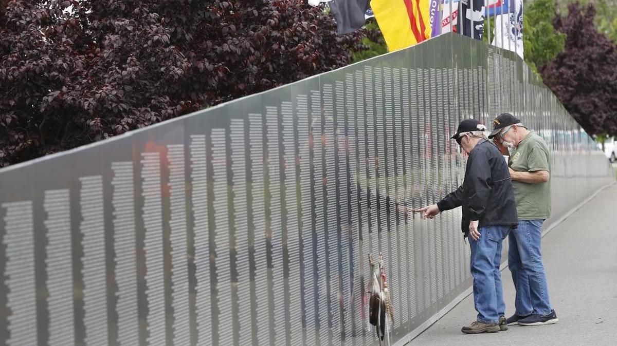 Pasco Vietnam veterans Doug Arbogast, left, and Willie Shearer, both 70, search out a name Thursday on the traveling Vietnam Memorial Wall at City View Cemetery in Pasco. Arbogast is also volunteering at the display. Watch a video at tricityherald.com/video