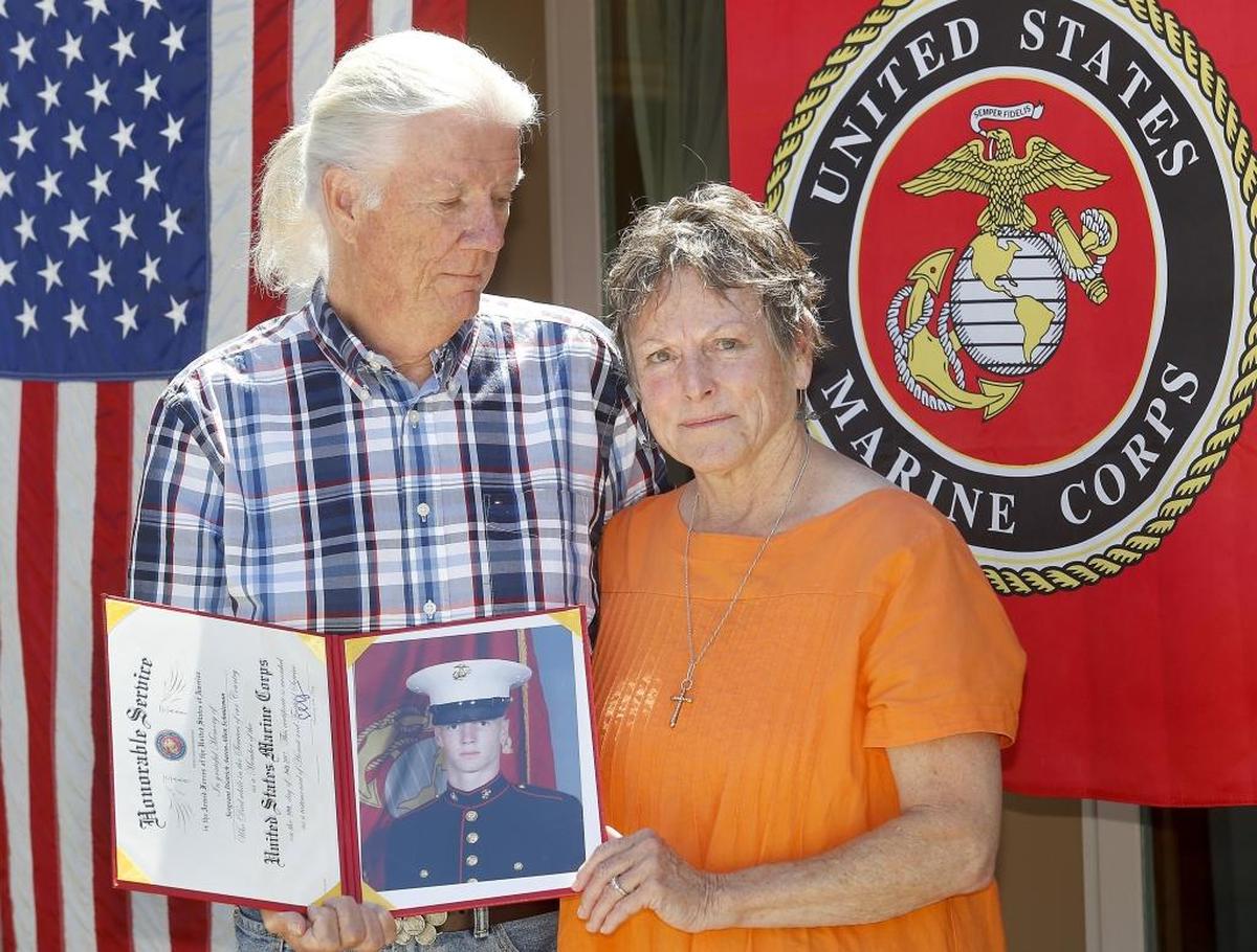 Susan and Eric Schmieman hold the 2010 Marine boot camp graduation portrait of their son, Dietrich, while standing in front of their Richland home. The Hanford High graduate was one of 16 people to die in a military plane crash in Mississippi.