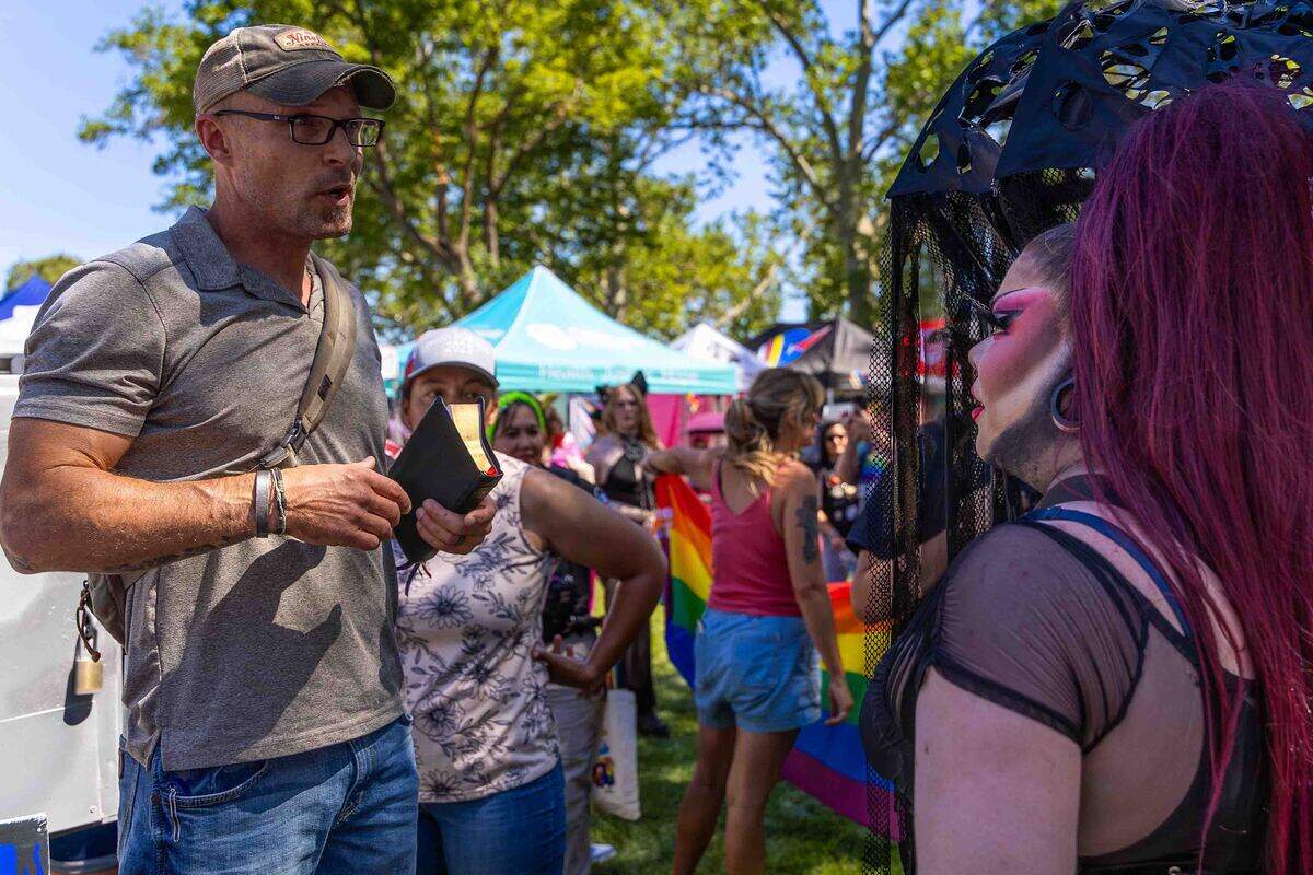 Pastor Eric Schonbachler of Lexington Reformed Baptist Church in Lexington, Oregon, left, speaks with drag performer Tatiana Rexia during the Tri-Cities Pride Festival. He was among a small group of protesters who attended the event to share their religious beliefs regarding homosexuality.