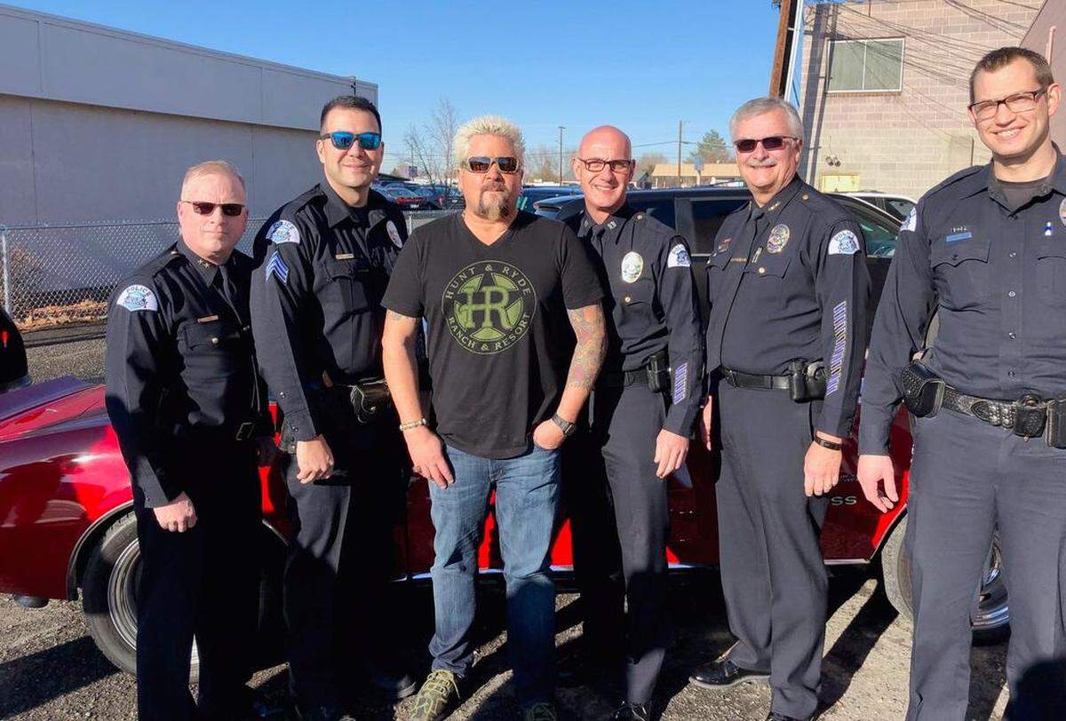 Food Network star Guy Fieri poses with Pasco Police Chief Bob Metzger, second from right, and other officers while Fieri was in Pasco this week filming at Vinney’s Bakery and Cafe for an episode of Diners, Drive-Ins and Dives