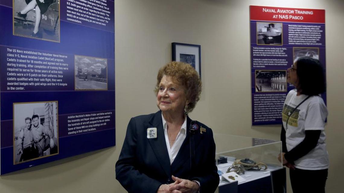 Altha Simmelink Perry, center, looks at a photo of herself Wednesday as Margie Murray of Kennewick looks at another display in the Naval Air Station Pasco exhibit that opened at the Reach museum in Richland. Perry was a member of the Navy WAVES and worked as a journalist in public relations at the Pasco Station Control Tower. See a video from the grand opening at www.tricityherald.com/video.