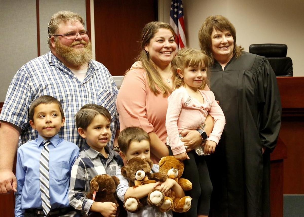 James and Angelica Sessions of Pasco stand with their new family Monday after Court Commissioner Pamela Peterson signed adoption documents for four siblingsin a Franklin County Superior Court.. From left, the youngsters are: Ajay, 9, Nathan, 7, Kyler, 5 and Layla, 4. Watch a video at tricityherald.com/video