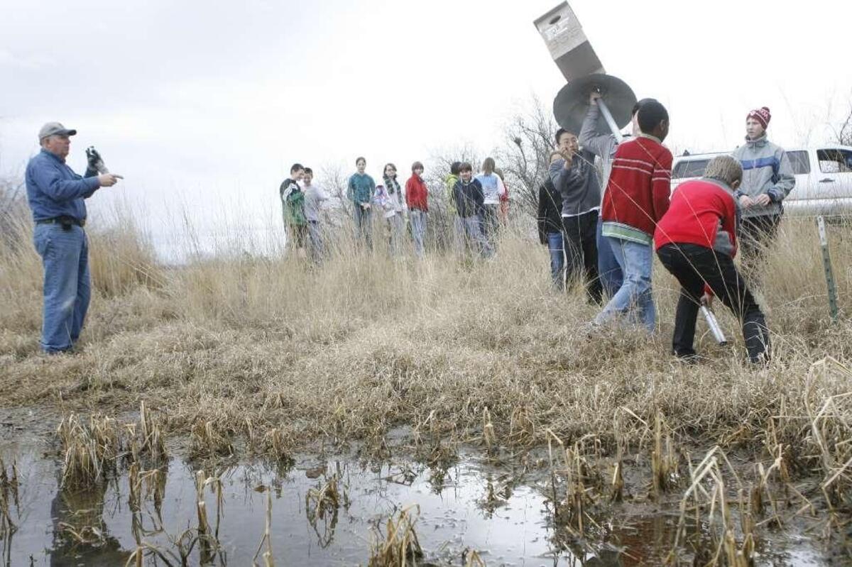 Dale Schielke, left, directs students installing wood duck nesting boxes at Barker Ranch in West Richland as part of a Richland Rod and Gun Club program.