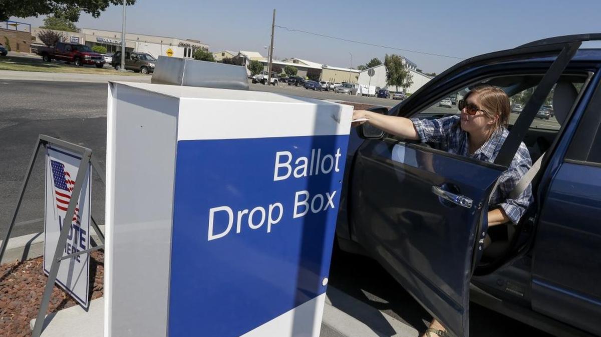 Regina McConaghy reaches out of her car to leave her ballot at a drop box near the Auditor’s Annex at 5600 W. Canal Dr. in Kennewick on Tuesday. McConaghy moved to the area a little over a year ago, although she did vote in the presidential election. This is her first local election in the Tri-Cities.