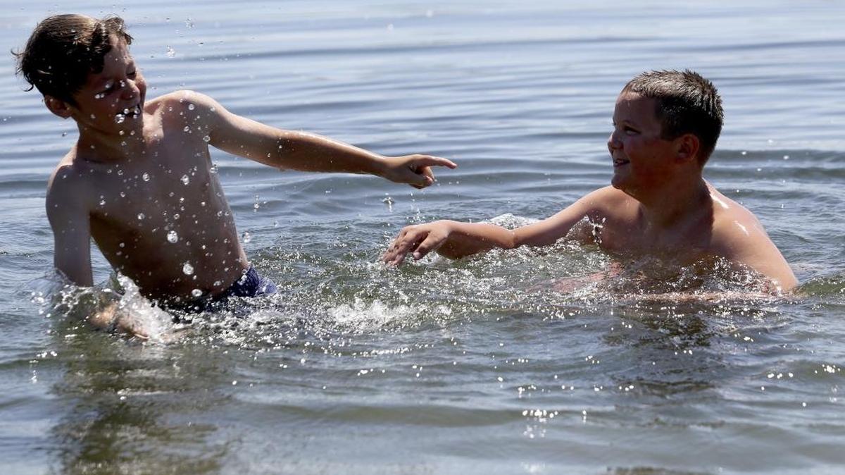 Damian Lewis, right, 11, splashes his friend Dennis Routh, 10, both of West Richland, while playing in the Columbia River Wednesday at Leslie Grove Park in Richland. Thursday will see a high near 93 with a chance of late evening thunderstorms, according to the National Weather Service.