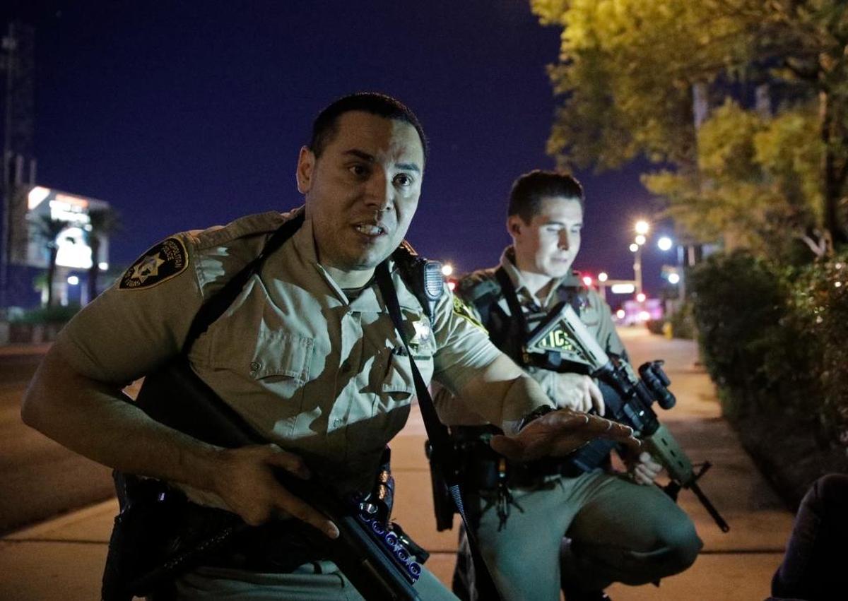 Police officers advise people to take cover near the scene of a shooting near the Mandalay Bay resort and casino on the Las Vegas Strip on Oct. 1.