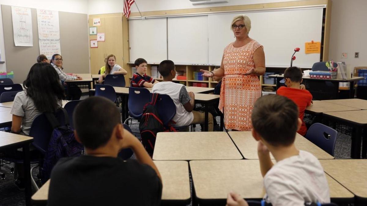 Amy King, a 6th-grade math teacher, laughs as she tells students there will be no homework last week during the first day of school at Desert Hills Middle School in Kennewick. Tri-City schools are giving away prizes in an effort to combat chronic absenteeism.