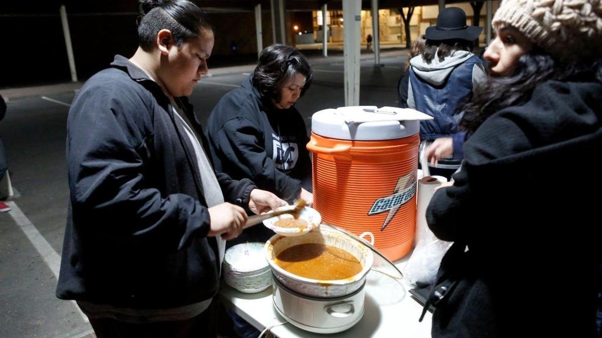 Volunteers with Operation Red Eye spoon chili into a bowl for one of the men or women who came to the Pasco Farmers Market where the street ministry set up shop the night of March 18.