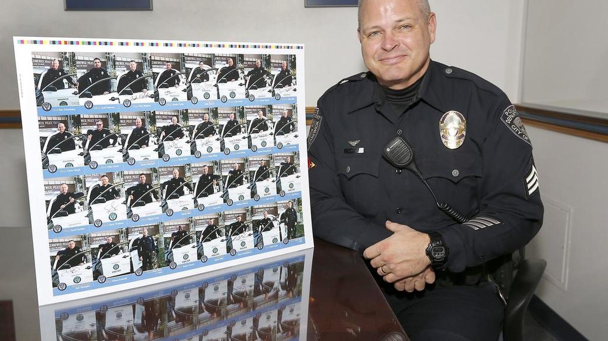 Sgt. Ken Lattin of the Kennewick Police Department sits near an uncut sheet of the department’s most recent officer trading cards. The 32-card series features officers, detectives, supervisors and Chief Ken Hohenberg. Espirit Printing in Kennewick donated the printing and Rich Breshears of Breshears Professional Photography took the photos free of charge.