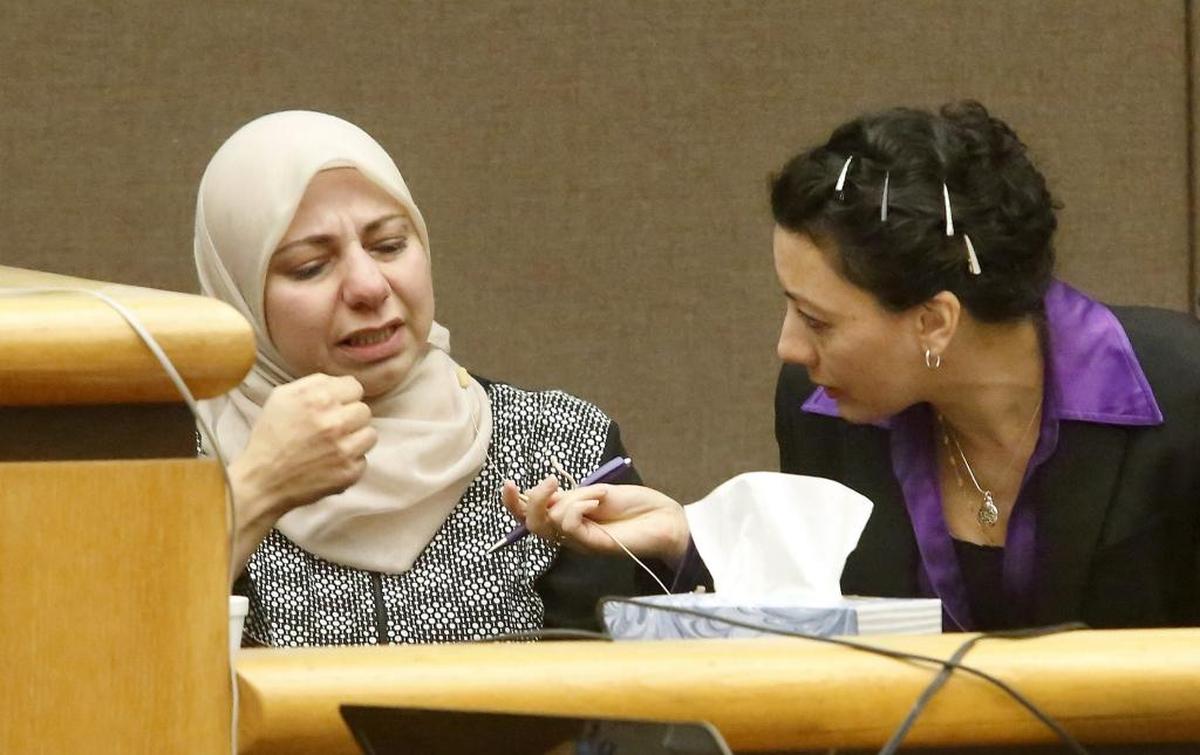 Stabbing victim Dania Z. Alhafeth motions with her hand how her husband "hit" her with a knife during an attack on Aug. 30 in their Kennewick apartment during her testimony Wednesday in Benton County Superior Court. Arabic court interpreter Diana Noman sits near Alhafeth to translate her statements. Watch a video at: tricityherald.com/video