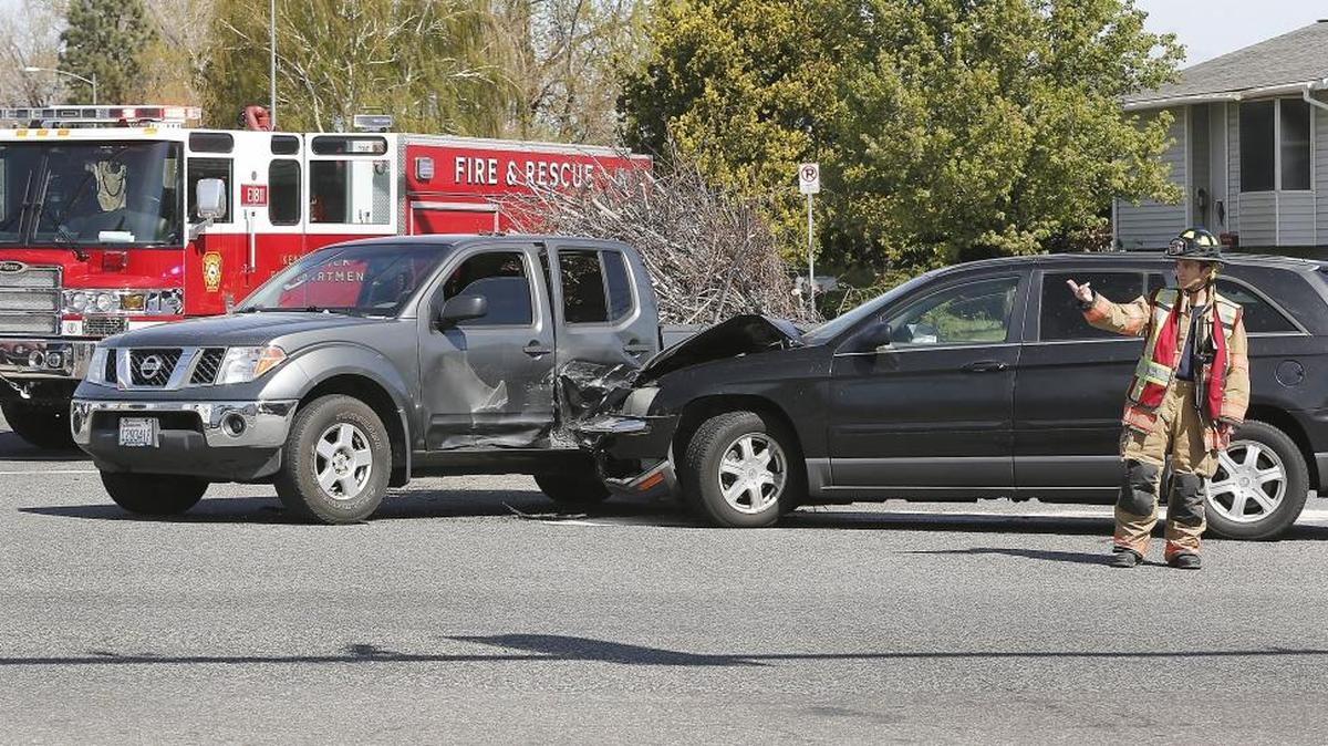 Kennewick firefighter Tom Cole helps direct traffic Tuesday afternoon at a two-vehicle collision at the intersection of South Olympia Street and West 27th Avenue in Kennewick. The driver of the late-model Nissan pickup apparently failed to stop for a red light while westbound on 27th Avenue and was struck by a northbound Chrysler minivan according the Kennewick Police officer Stan Howard. The unidentified male driver of the Chrysler was taken to an area hospital for treatment of minor injuries from the airbag deployment. The pickup driver was cited, said Howard.