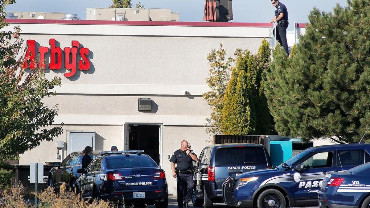 
Pasco police Sgt. Rodrigo Pruneda climbs down from the roof Tuesday morning while investigating a burglary at the Arby's restaurant on Road 68. Employees initially thought the roof was caving in but police discovered someone had broken in through the roof and stolen some cash and other items.
