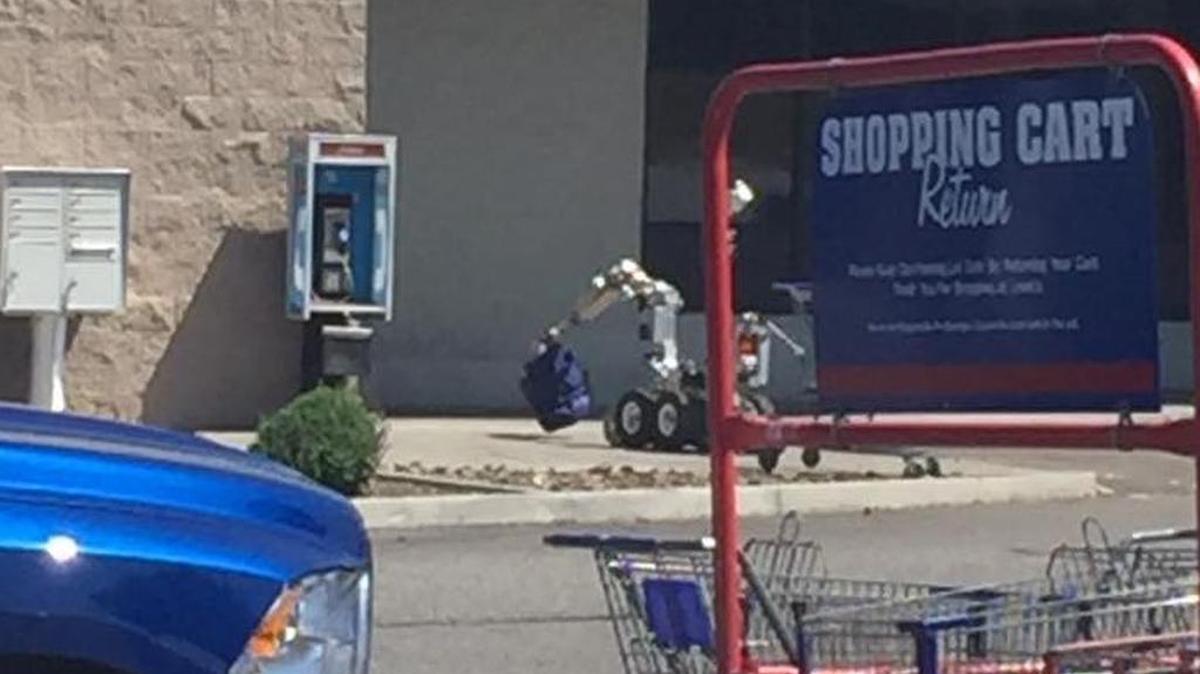 The Richland Bomb Squad robot checks on a sleeping bag left on top of a payphone in Kennewick on Wednesday.