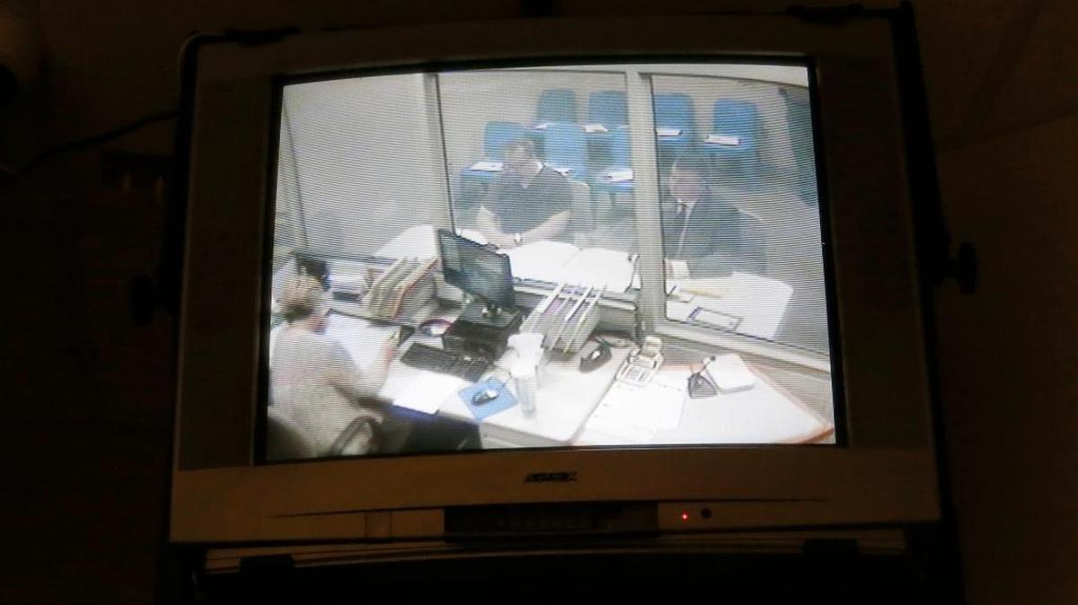 Judge Terry M. Tanner sits at the defense table, instead of on the Benton County District Court bench, after his arrest late Tuesday for driving under the influence. Tanner, left, was represented by Scott Johnson during his first appearance. The hearing, held in the Benton Count jail, was televised in a public room in the jail’s lobby.