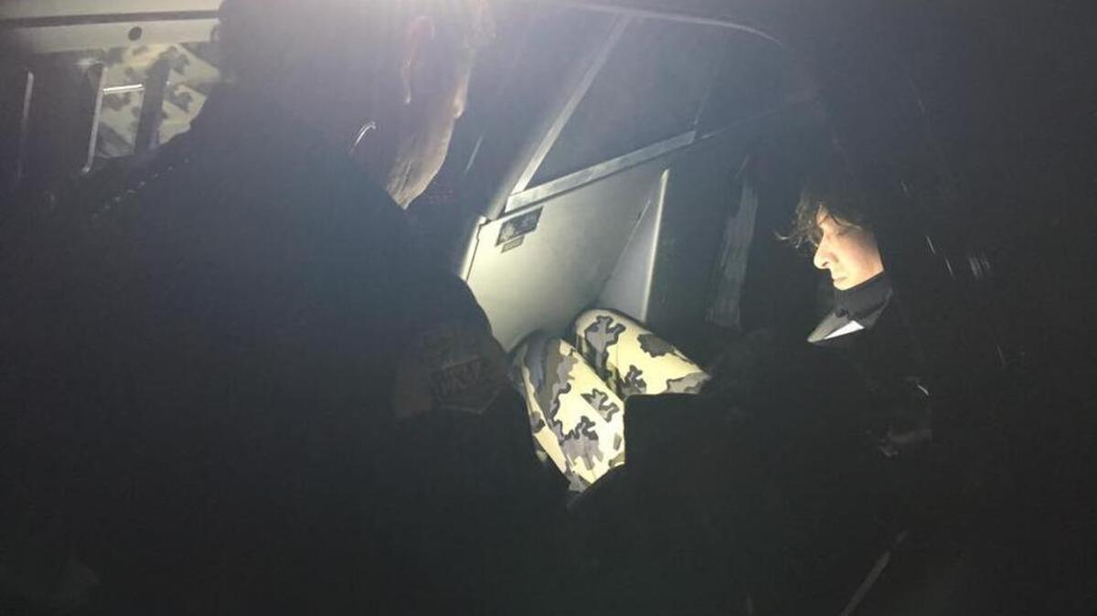Travis Hintz sits in the back of a Pasco police car while he is questioned.