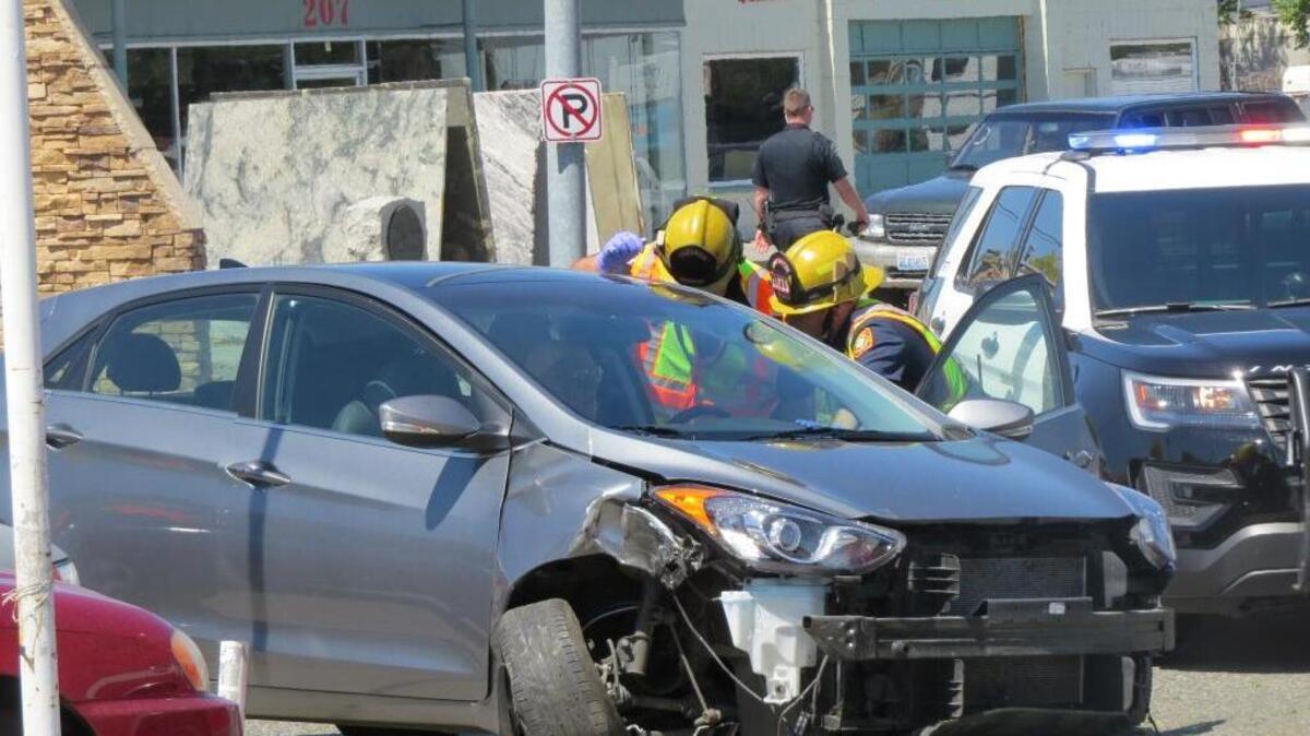 Kennewick police and fire crews check the driver of a car who lost control and hit a light pole Friday at Columbia Drive and Benton Street. The driver was arrested on investigation of drunken driving.
