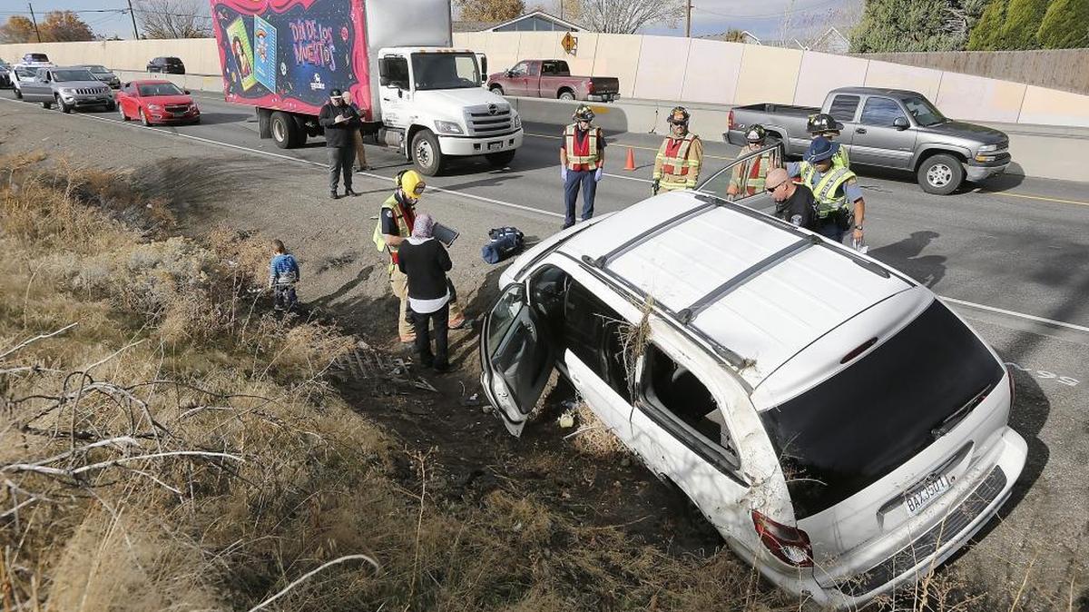 Fire and police officials investigate the scene of Wednesday's two-vehicle collision involving a truck and mini-van in the northbound lanes of Highway 395 near Yelm Street in Kennewick. Police say the female van driver collided with the front of the truck while attempting to pull into traffic on the two-lane roadway from a merge lane. The mini-van spun out, struck the center barrier and rolled before coming to rest on its wheels in the ditch facing the opposite direction. Trooper Daniel Mosqueda of the Washington State Patrol said the van driver will be cited for an improper lane change. No one was injured.