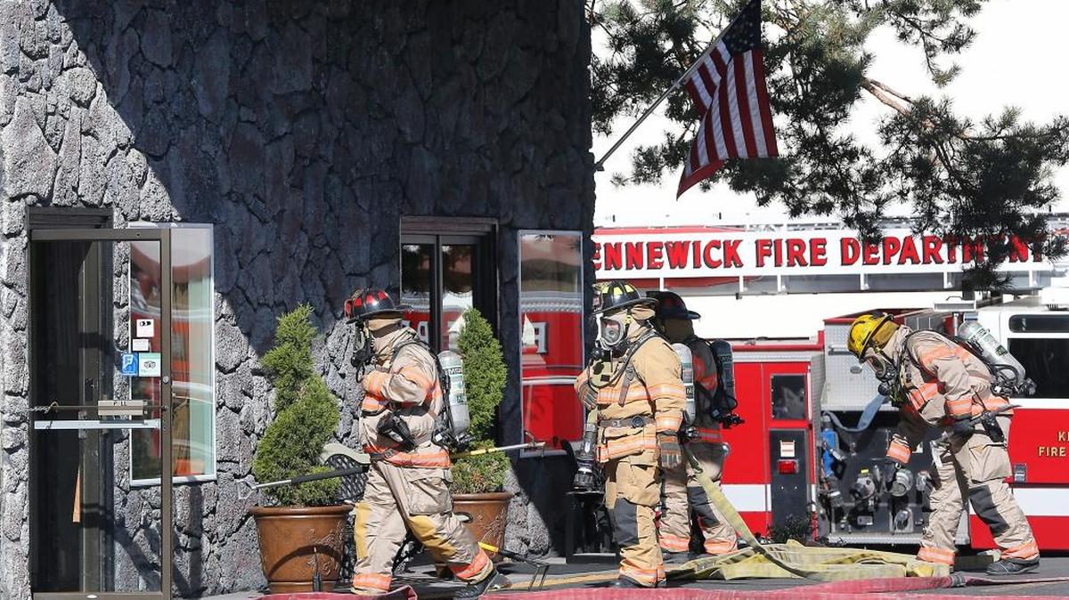
Kennewick firefighters enter the Kennewick Suites hotel Monday morning to extinguish an electrical fire in the wall near the laundry room. Fire officials say maintenance workers were working in the area when the fire started. The building was temporarily evacuated but no one was hurt. Watch a video at: www.tricityherald/video.
