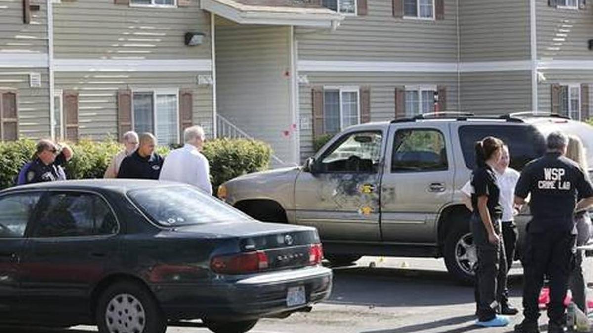 Investigators from the Kennewick Police Department, members of the Washington State Patrol Crime Scene Team and Benton County prosecuting attorneys work Tuesday morning at the scene of Monday night's fatal suspected gang shooting in an apartment complex at 1138 W. 10th Ave. in Kennewick. Police officials say victim Jorge Antonio Jimenez, 20, was hit by two bullets when he confronted two suspects scratching their gang insignia into the paint on the door of his gold SUV.