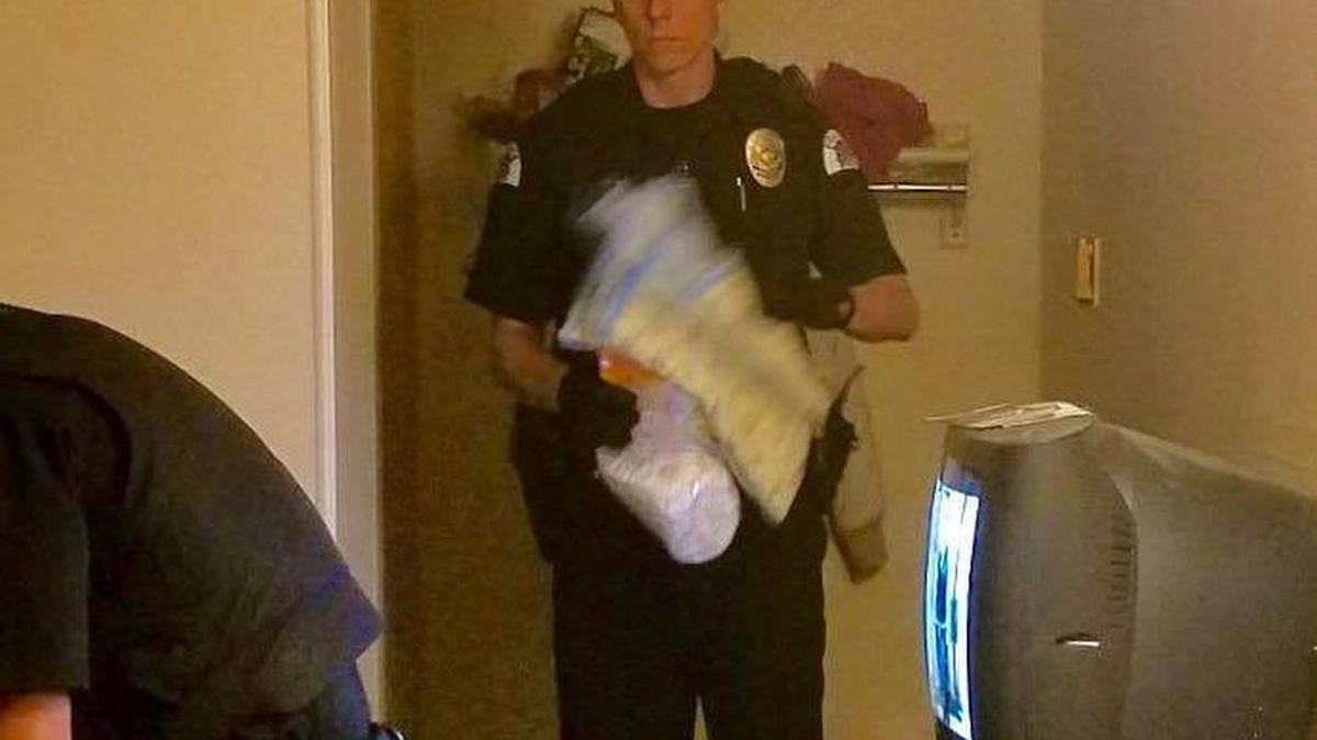 Pasco police Officer Kevin Frantz is collecting a 3-year-old girl’s clothing and a diaper bag at the Rodeway Inn while the girl was being placed into protective custody on Wednesday.