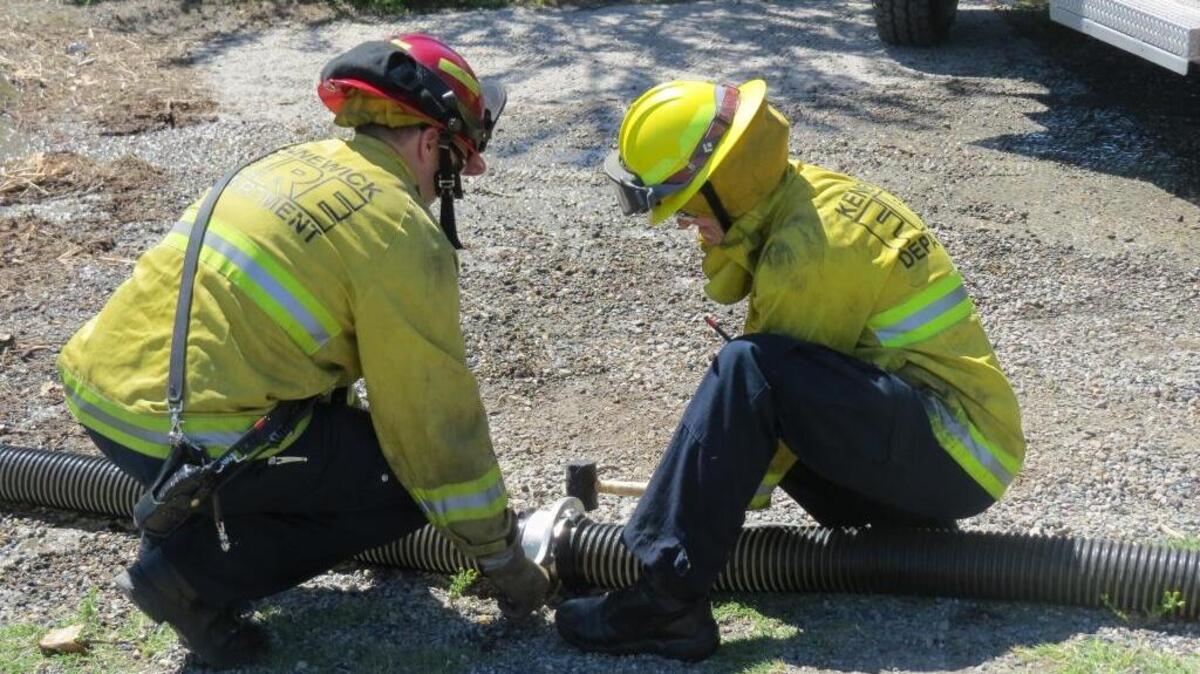 Kennewick firefighters dismantle a pipe connecting a firetruck to the Columbia River as they practice for the upcoming wildfire season.