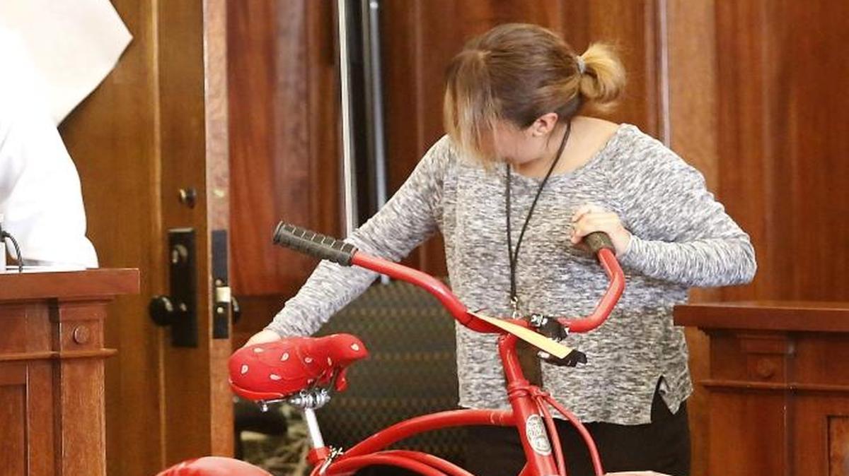 Deputy clerk Beatris Martinez is followed by Deputy Prosecutor Dave Corkrum as she brings a shooting victim’s bike into a Franklin County courtroom on Thursday. The bike belonged to Juan C. Melgoza, who prosecutors claim was shot and killed by Chris Pedroza-DeSantiago in February 2015.