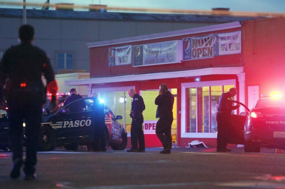 Pasco police gather outside of Vinny's Bakery & Cafe on 10th Avenue and Lewis Street in Pasco on Feb. 10, 2015, after three officers shot Antonio Zambrano-Montes.