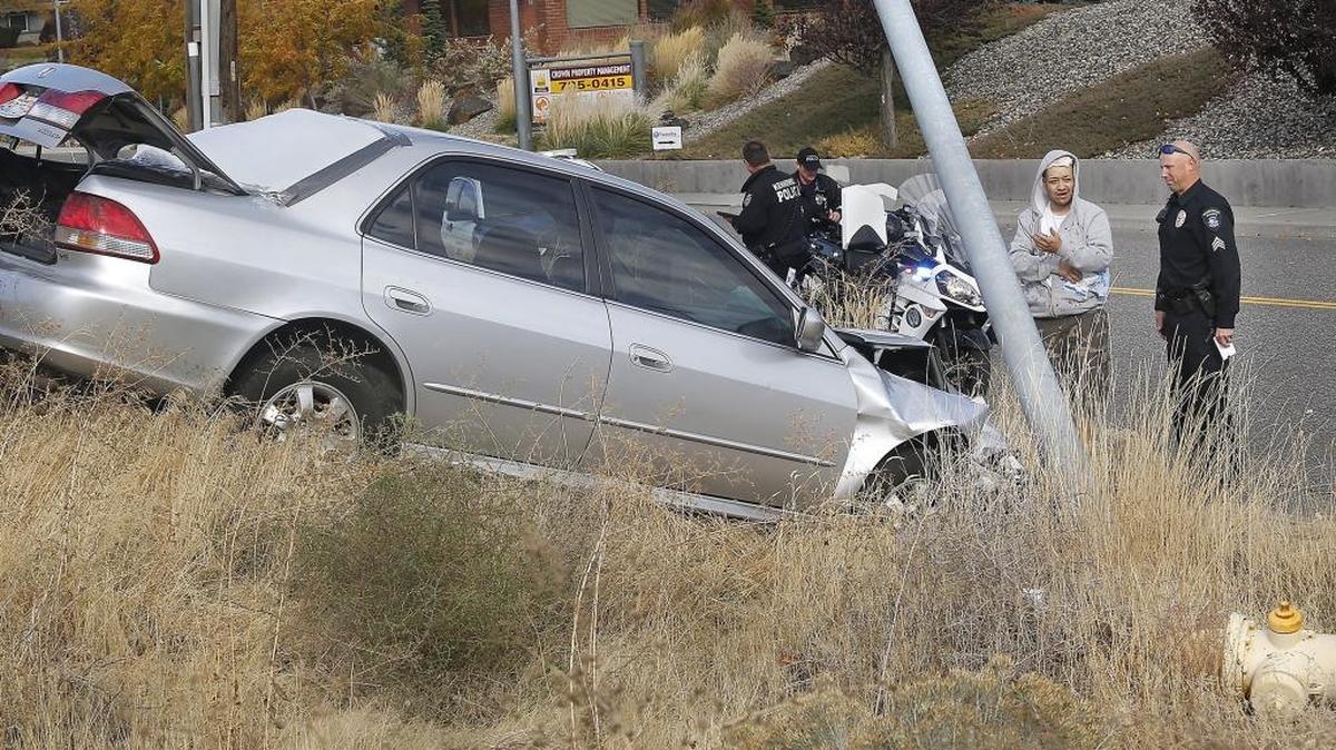 Driver Ruben Torres, 35, of Kennewick talks with Sgt. Matt Newton of Kennewick Police Department Thursday afternoon following his single car wreck in the 900 block of North Colorado Street in Kennewick. Torres told officers he fell asleep at the wheel because he stayed up all night moving. He was treated at the scene by Kennewick Fire Department paramedics for a cut on his head.