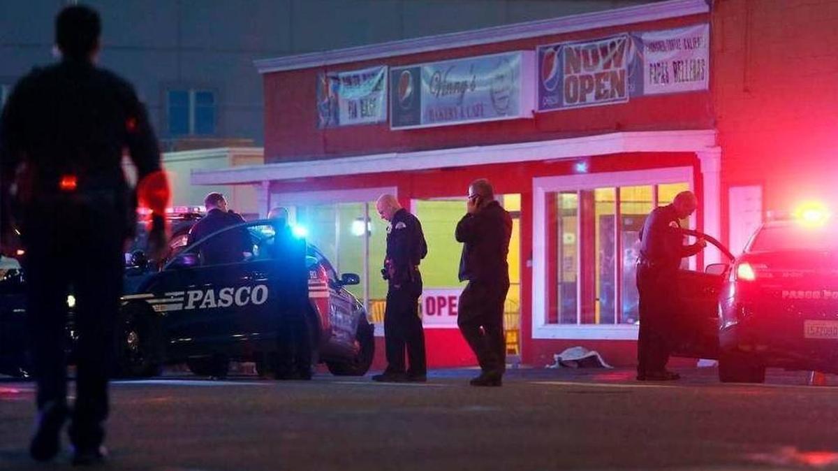 Pasco police officers gather outside of Vinny's Bakery and Cafe on 10th Avenue and Lewis Street in Pasco on Feb. 10, 2015, following the shooting death of Antonio Zambrano-Montes by Pasco police officers.