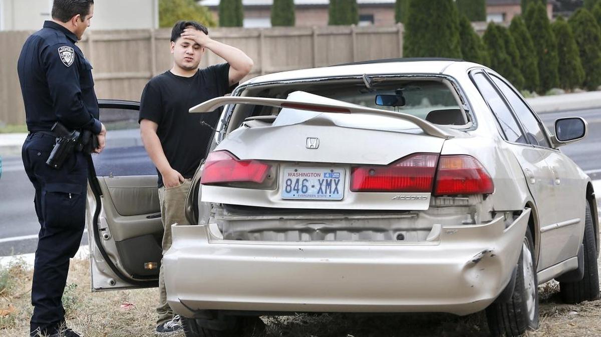 Driver Christopher Cervantes, 19, answers questions Thursday from Kennewick police officer Scott Peterson after losing control of the Honda sedan he was driving and slamming sideways into a street light on West Fourth Avenue near South McKinley Place. Witnesses reported the Kennewick teen was speeding and swerved out of control when attempting to pass a vehicle in front of him in the eastbound lane of Fourth Avenue. He apparently overcorrected, slid over the curb and hit the light pole causing the support arm and light to fall to the ground. He was taken to the hospital for treatment of a possible concussion and other minor injuries. Police officials say he will be cited for reckless driving. Watch a video at: www.tricityherald.com/video.