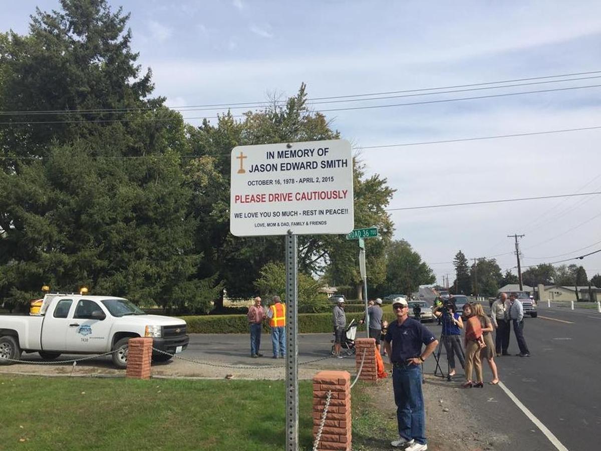 John Smith looks at the sign installed at Road 36 and Sylvester Street in Pasco in memory of his son, Jason, who was killed by a hit-and-run driver in April 2015.