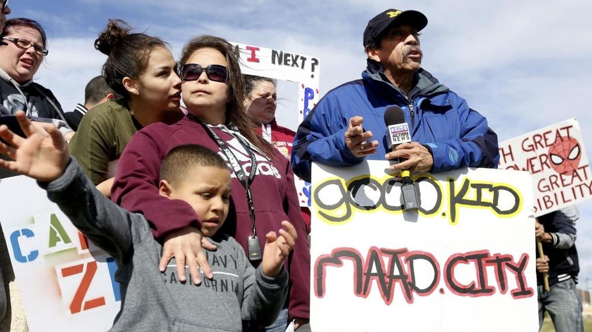 Jessica Moreno, left, whispers into the ear of her sister, Erica, standing with son Damien, as their father, Miguel Moreno, speaks Monday during a press conference at the Benton County Justice Center in Kennewick. Miguel’s son, Marc Moreno, 18, passed away in his cell at the Benton County jail on March 11.