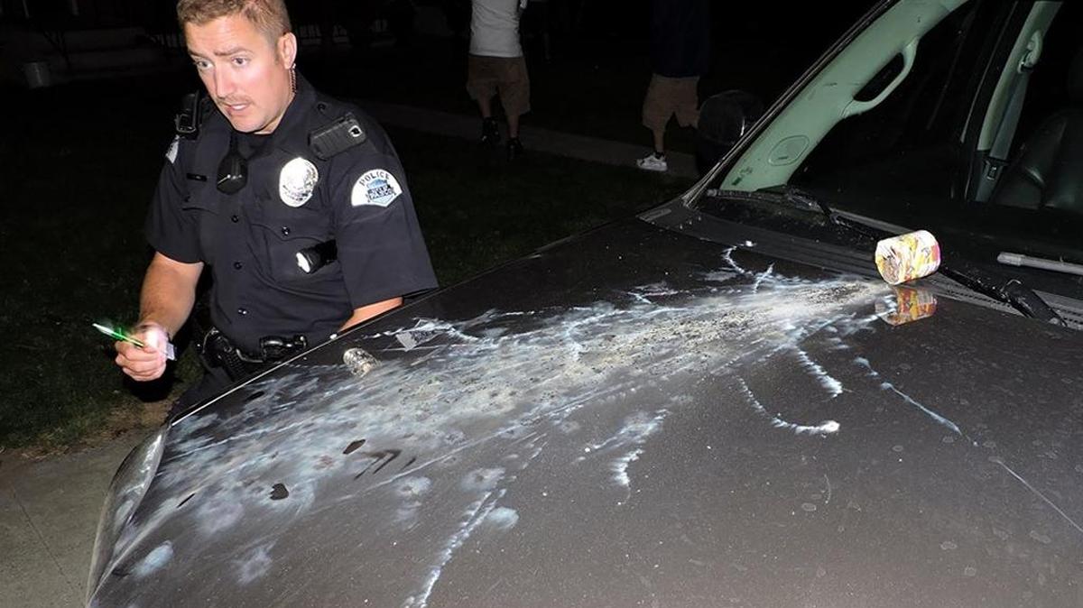 Pasco Officer Travis Park investigates a fountain-style firework scorching the hood of a Yukon SUV at the 1600 block of North 13th Avenue on July 4.