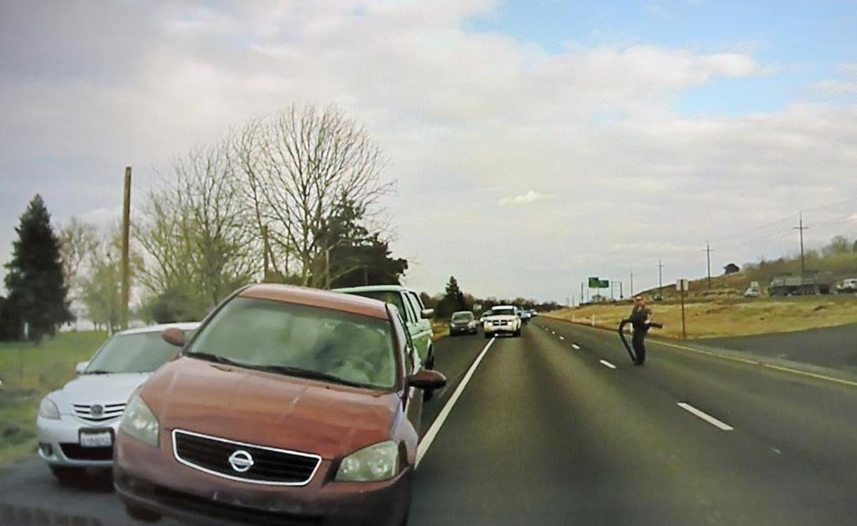 Benton County sheriff’s Sgt. Jason Erickson looks on as a Nissan Altima allegedly driven by Richard Vasquez hits other cars to escape a spike strip Wednesday.