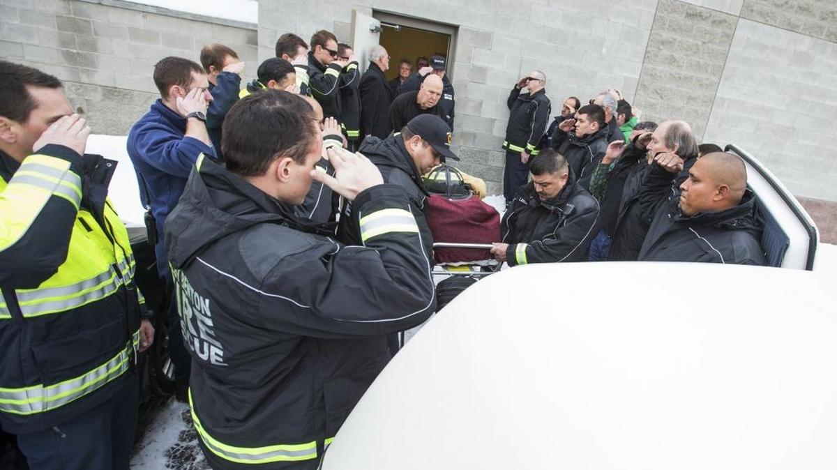 Firefighters from West Benton Fire and Rescue are joined by other emergency personnel Monday as the body of James S. Wildman, 23, is placed into a vehicle at the coroner’s office in Yakima. Wildman, a firefighter with the department, was one of two men killed in a crash Saturday after the vehicle he was driving landed in the Naches River.