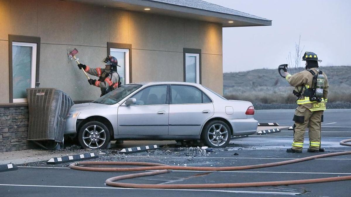 Pasco firefighters check a building's exterior wall for the spread of fire after a four-door sedan crashed into the unoccupied office building early Tuesday morning at 1330 Kartchner Street in Pasco. Fire officials say the injured male driver was pulled from the damaged and burning vehicle by a police officer and passerby. Firefighters quickly put out the car fire before it spread. The driver was taken to a local hospital for treatment. The cause of the wreck is under investigation. Watch a video at: www.tricityherald.com