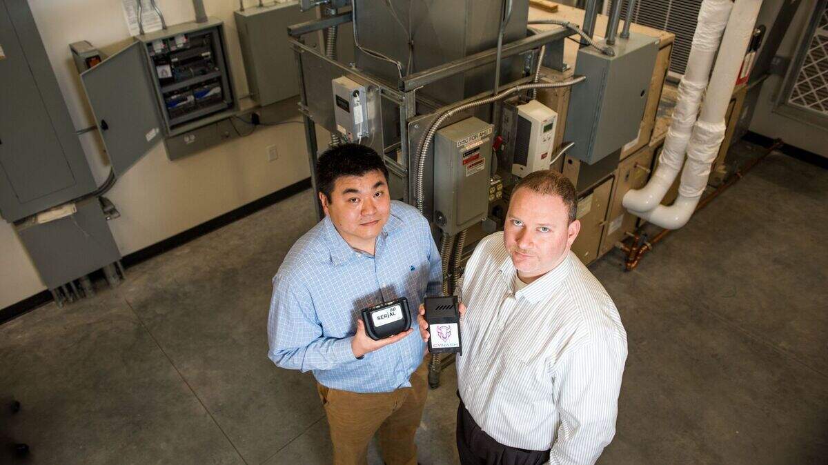 PNNL cybersecurity experts Eric Choi, left, and Thomas Edgar helped develop SerialTap, an inexpensive, compact device that connects older systems, such as those found in many hydroelectric facilities, to advanced networks and cybersecurity tools.
