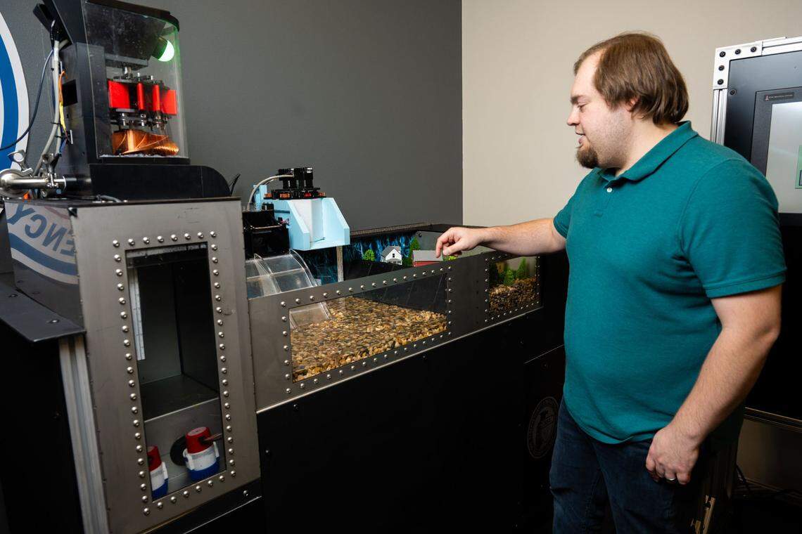 William Hofer, a cybersecurity engineer, demonstrates a hydropower generation test platform developed at PNNL that allows users to perform security research on industrial control systems and engage in simulated risk scenarios.