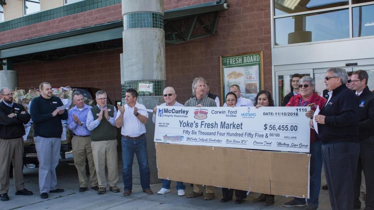 Officials presented a check for $56,455 at Yoke’s Fresh Market in West Richland on Thursday.