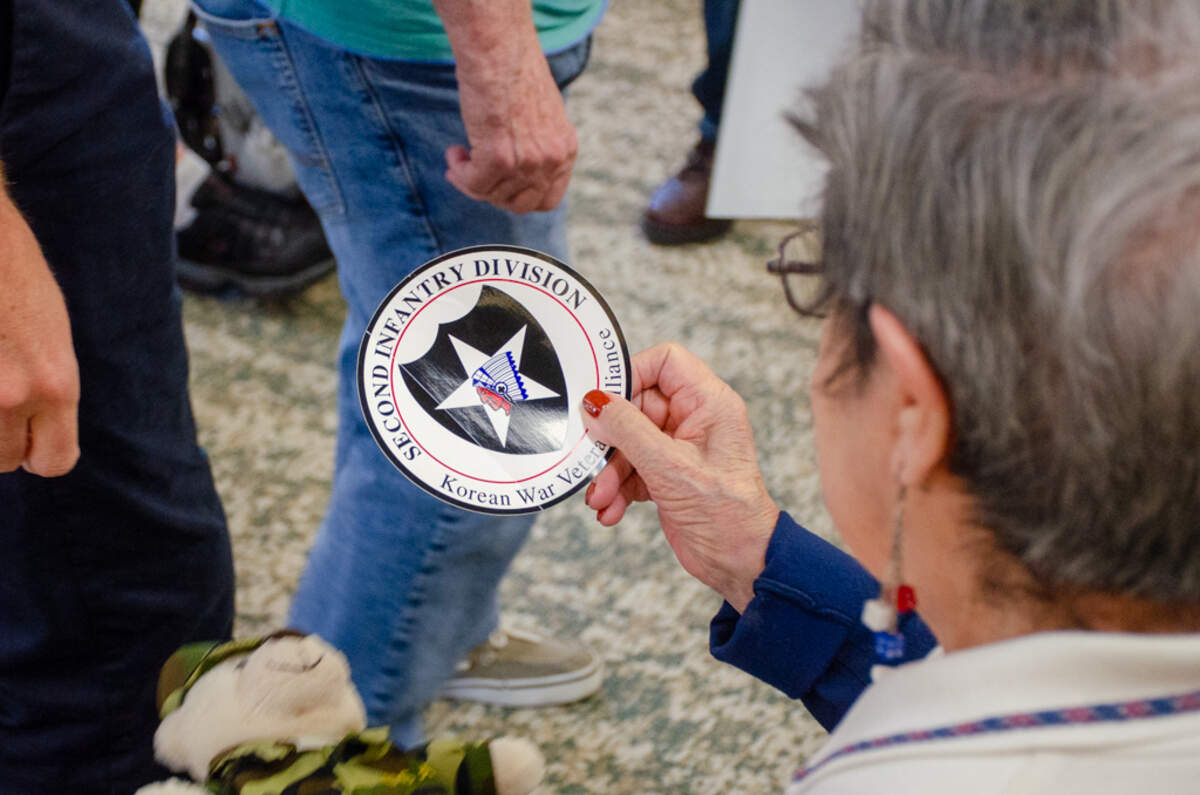 Gloria Space, 90, a resident of Brookdale Canyon Lakes senior living community in Kennewick, holds a sticker insignia and bear in commemoration of her late husband of 52 years, Robert Space, an Army veteran who served in the Korean War.