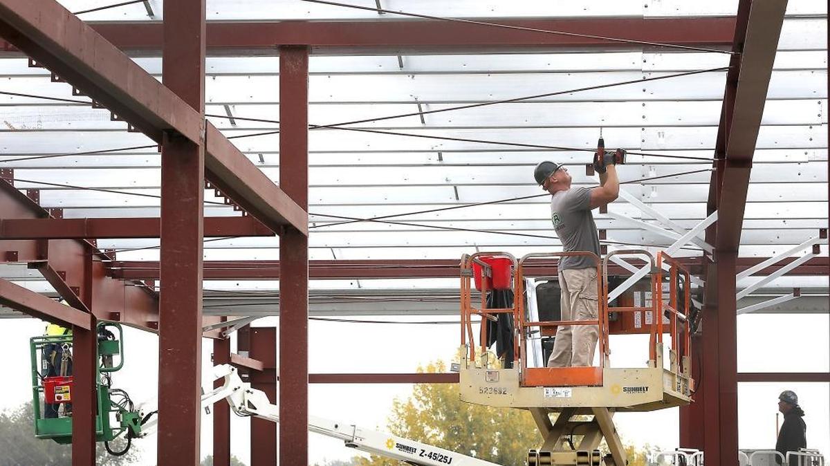 
Russel Petty with LCR Construction in Kennewick works Thursday on the metal roof for the new 15,000-square-foot Kennewick Irrigation District administration building being built at 2015 S. Ely St. The $2.25 million structure next to KID’s shop facilities is scheduled to be finished later this winter. The agency is expected to move out of its downtown office by Jan. 1.
