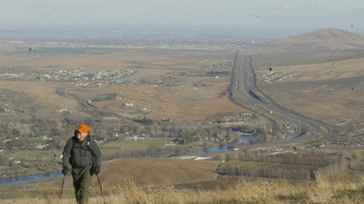 A hiker checks out the early winter views along the Horse Heaven Hills above the Yakima River Valley near Benton City.
